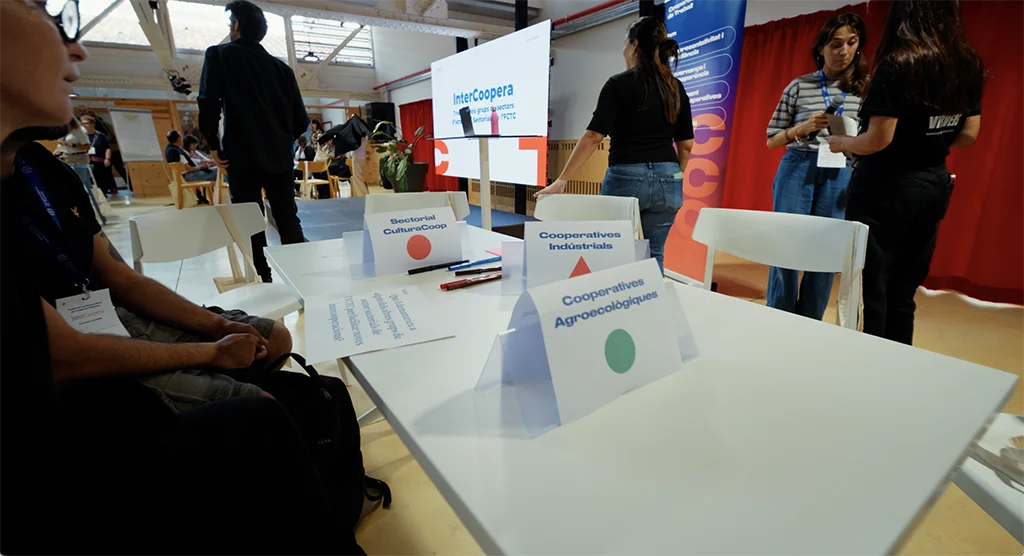 Las mesas de trabajo de InterCoopera con los carteles de los grupos sectoriales CultureCoop, Cooperativas Industriales y Cooperativas Agroecológicas.