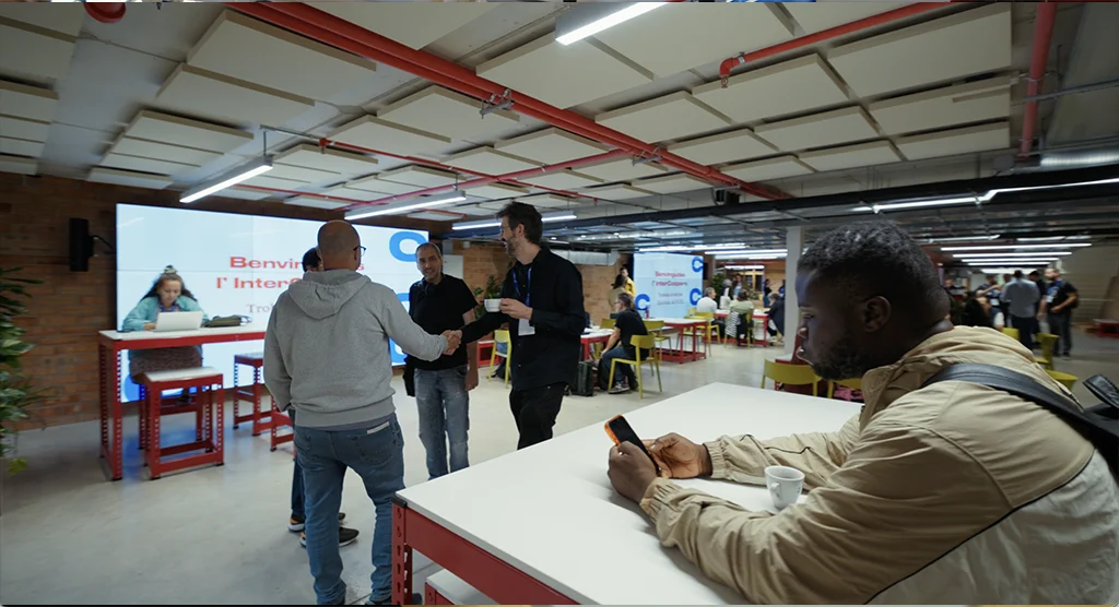 Los participantes se saludan en la zona de bienvenida de InterCoopera, en Bloc4BCN.